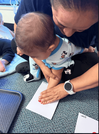 Teacher caring for and helping infant