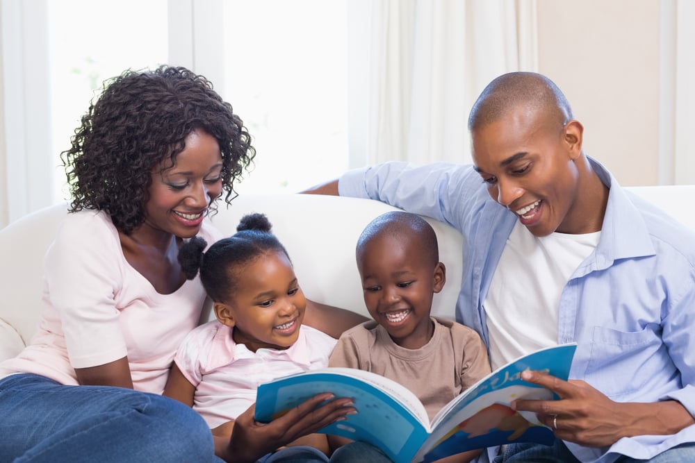 Happy family on the couch reading storybook at home in the living room-1