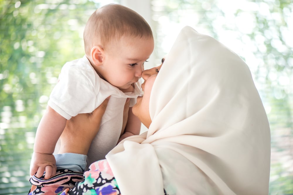 Women with an islamic scarf holding a gorgeous toddler