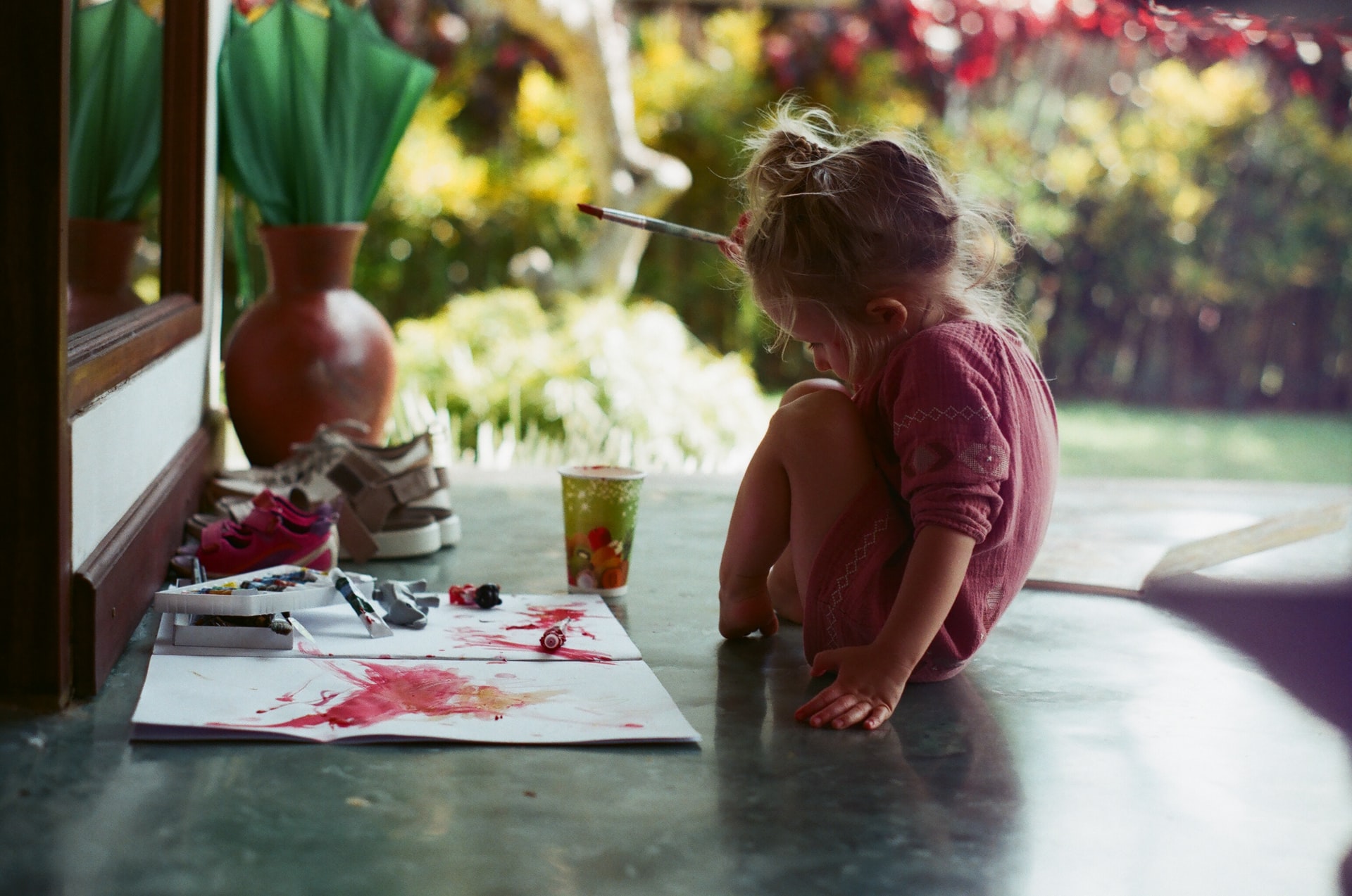 young girl paints on the floor