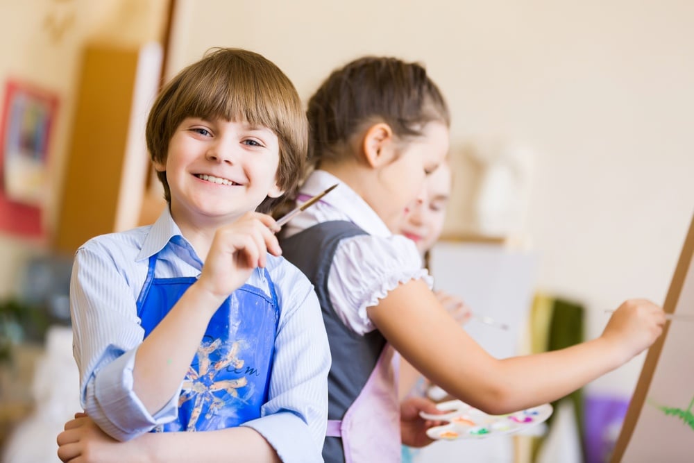 Little children painting and playing at kindergarten