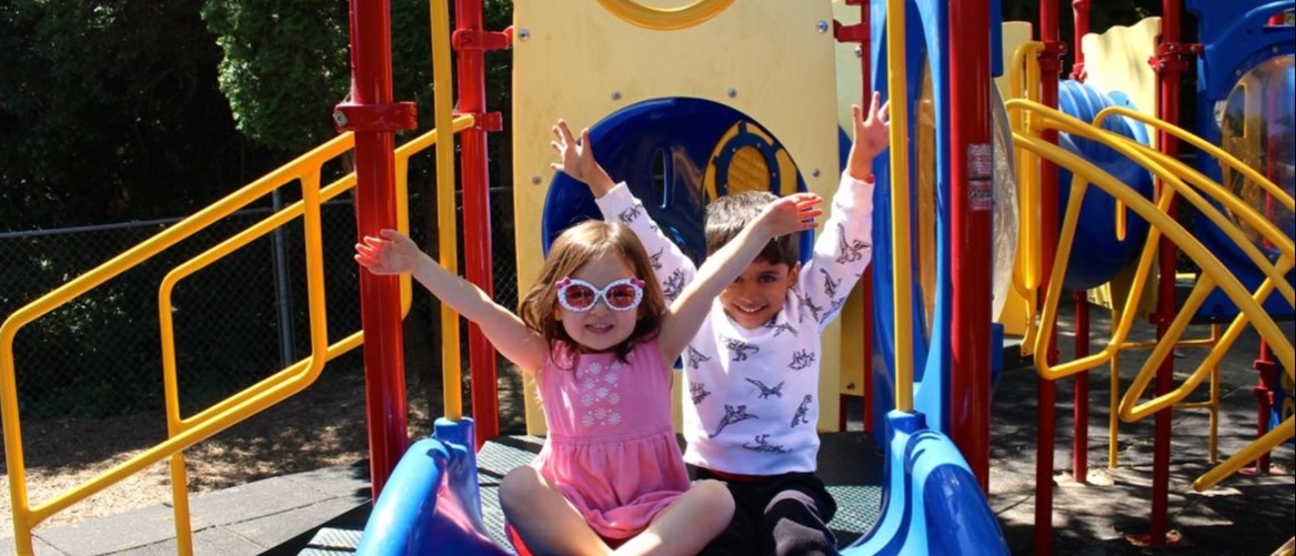 san_mateo_children_on_slide_arms_up-447870-edited